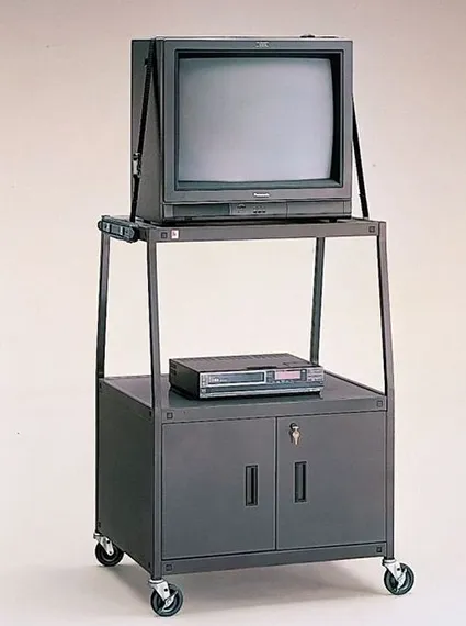 [wheels TV cart into classroom]